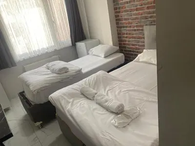 three beds in a room with a brick wall at lastbest hotel in Istanbul