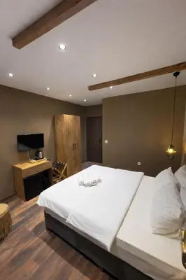 a bedroom with a large white bed and a television at Goga Otel in Sarıyer