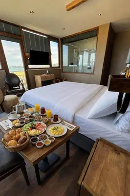 a room with a bed and a table with food on it at Goga Otel in Sarıyer