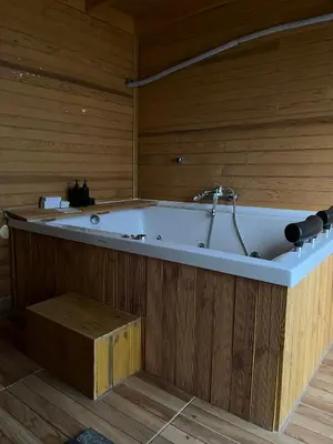 a bath tub in a room with a wooden wall at Goga Otel in Sarıyer