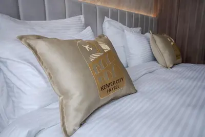 a gold pillow on a bed with white pillows at Kemer City Hotel İstanbul Airport in Kemerburgaz
