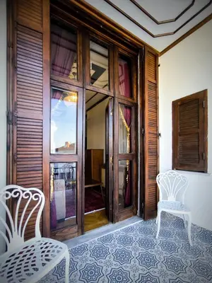two white chairs sitting in front of a door at Palm Villa Büyükada in Istanbul