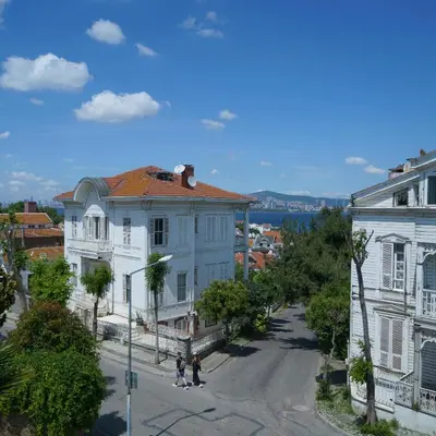 two people walking down a street in a city at Palm Villa Büyükada in Istanbul