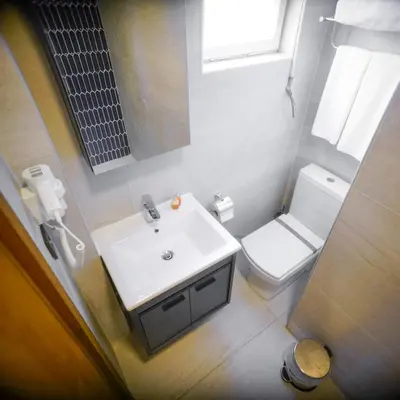 a bathroom with a white sink and a toilet at Palm Villa Büyükada in Istanbul