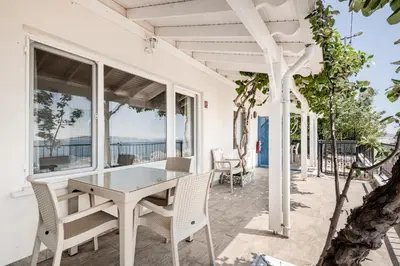 a white dining room with a table and chairs at Marmara Yali Evi in Marmara