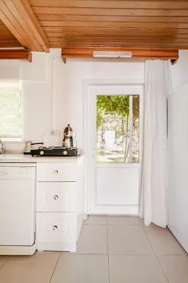 a kitchen with white cabinets and a door at Marmara Yali Evi in Marmara