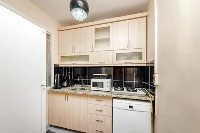 a kitchen with wooden cabinets and a white microwave at MARMARA DREAM APARt in Istanbul
