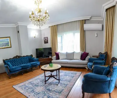 a living room with blue furniture and a chandelier at Villa Denizci in Sapanca