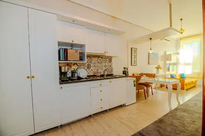 a kitchen with white cabinets and a dining room at Taksim Nil Suite in Istanbul