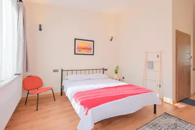 a bedroom with a large bed and a red chair at Casa Nozze in Istanbul
