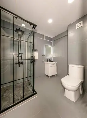 a bathroom with a toilet and a glass shower at Cenova Suite Hotel in Istanbul
