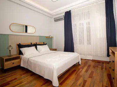 a bedroom with a large white bed and a mirror at Taksim Green Flat Apartment in Istanbul