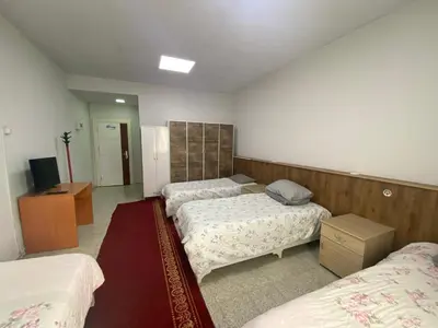 a bedroom with three beds and a television in it at Kocaeli Konaklama in Izmit