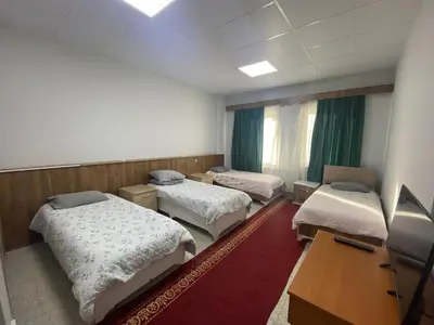 a room with three beds and a desk and a television at Kocaeli Konaklama in Izmit