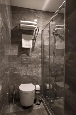 a bathroom with a toilet and a glass shower at Snog Rooms & Suites in Istanbul