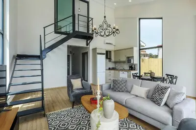 a living room with a gray couch and a staircase at New Balturk Nature Villas in Sapanca