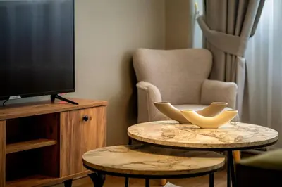a living room with a tv and a table and a chair at Cozy and Modern 3BR with Private Patio in Beşiktaş in Istanbul