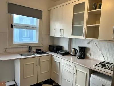 a kitchen with white cabinets and a sink at Elegant and Cozy 2BR with Balcony near Taksim in Istanbul