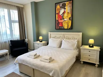 a bedroom with a large bed and a painting on the wall at Elegant and Cozy 2BR with Balcony near Taksim in Istanbul