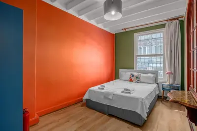 a bedroom with orange and green walls and a bed at Cozy Private Home in Kadıköy – Near Coast Ferry in Istanbul