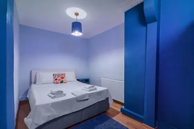 a small room with a bed with blue walls at Cozy Private Home in Kadıköy – Near Coast Ferry in Istanbul
