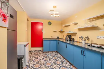 a kitchen with blue cabinets and a red door at Cozy Private Home in Kadıköy – Near Coast Ferry in Istanbul