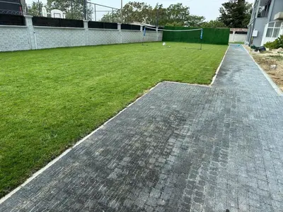 a cobblestone walkway next to a field of grass at Lux Villa Silivri Kavakli in Silivri