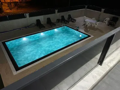 a large swimming pool with a table and chairs at Lux Villa Silivri Kavakli in Silivri