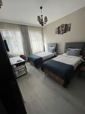 a hotel room with two beds and a television at Massa Home TAKSİM in Istanbul