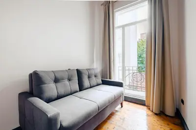 a couch in a living room with a large window at Cozy Flat with Balcony Near Istiklal Avenue in Istanbul