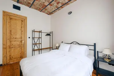 a bedroom with a white bed and a wooden floor at Cozy Flat with Balcony Near Istiklal Avenue in Istanbul