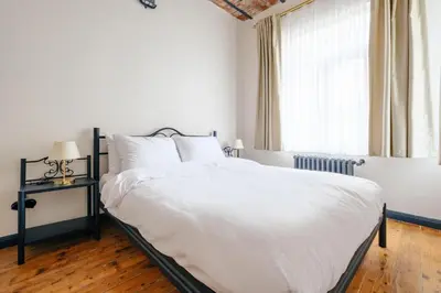 a bedroom with a large white bed and a window at Cozy Flat with Balcony Near Istiklal Avenue in Istanbul