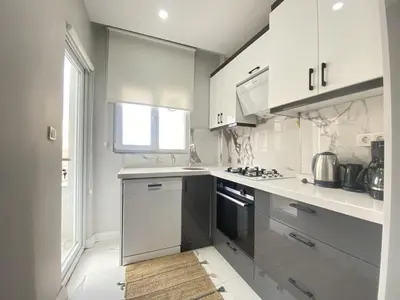 a kitchen with white cabinets and a stove top oven at Central Comfortable Flat in Historic Balat in Istanbul