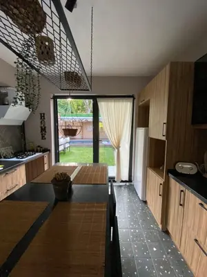 a kitchen with wooden cabinets and a large window at Fcvillasapanca in Sapanca