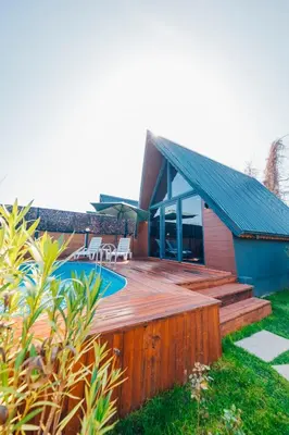 a house with a wooden deck and a swimming pool at Sapanca Sunday Bungalov Resort Otel in Sapanca