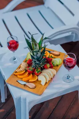 a tray of fruit on a table with two glasses of wine at Sapanca Sunday Bungalov Resort Otel in Sapanca