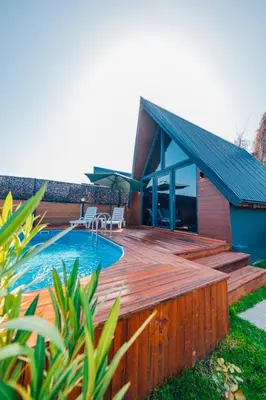 a house with a wooden deck and a swimming pool at Sapanca Sunday Bungalov Resort Otel in Sapanca