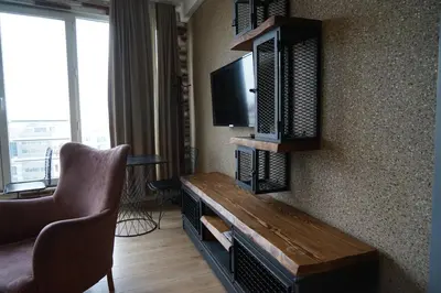 a hotel room with a television and a couch and a chair at SE Group Corner Suites in Istanbul