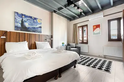 a bedroom with a large bed and a chair at Akçe 6 in Istanbul