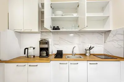 a white kitchen with white cabinets and a sink at Akçe 6 in Istanbul