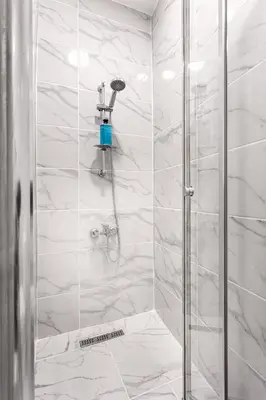 a bathroom with a shower with white marble walls at Akçe 6 in Istanbul