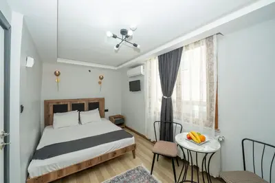 a bedroom with a bed and a table and a window at Deluxe Valeria in Istanbul