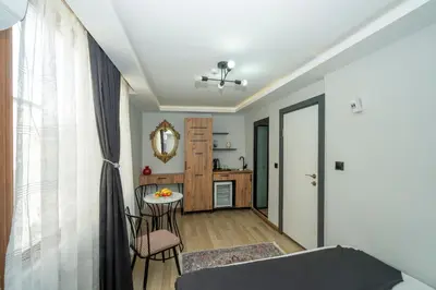a living room with a table and a kitchen at Deluxe Valeria in Istanbul
