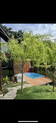 a swimming pool in a yard with trees and a house at Galaxy Housing
