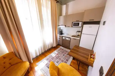 a kitchen with a couch and a table and a refrigerator at Flex Pera in Istanbul