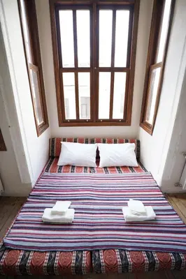 a large bed in a room with a cat sitting on it at i1 Historic House Hotel with Gorgeous View in Istanbul