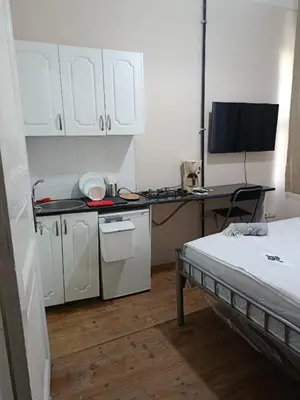 a kitchen with white cabinets and a bed in a room at i1 Historic House Hotel with Gorgeous View in Istanbul