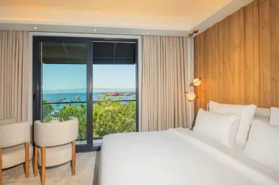 a bedroom with a white bed and a large window at Premier Lounge Hotel in Tuzla
