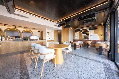 a restaurant with a table and chairs and a bar at Premier Lounge Hotel in Tuzla
