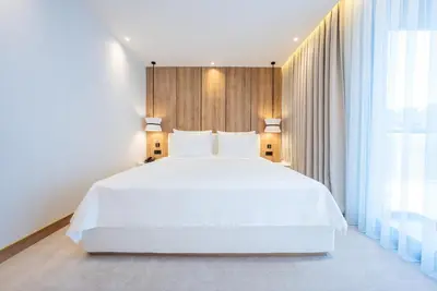 a bedroom with a large white bed and a window at Premier Lounge Hotel in Tuzla